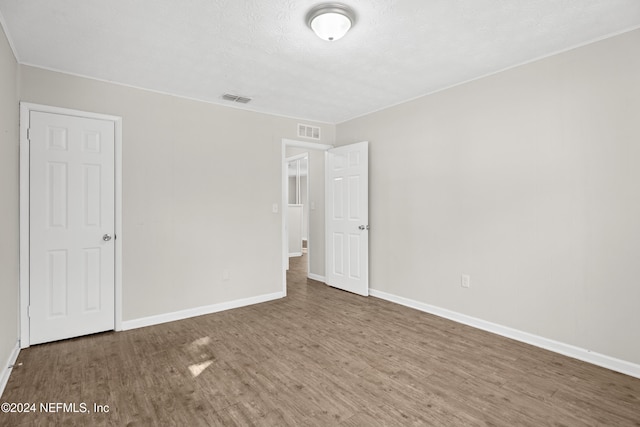 unfurnished bedroom featuring wood-type flooring and a textured ceiling