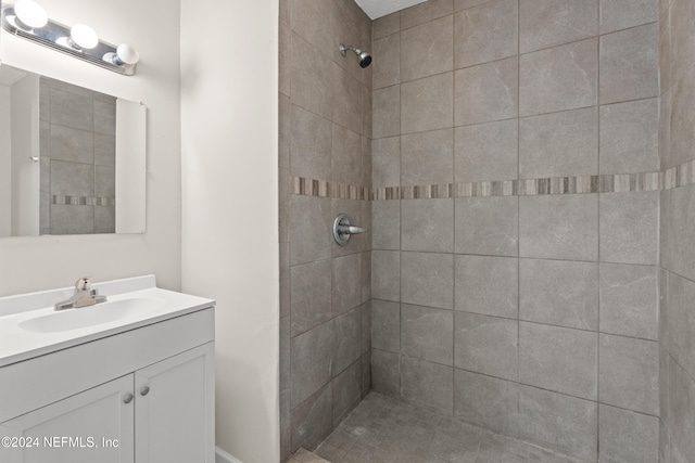 bathroom with a tile shower and vanity