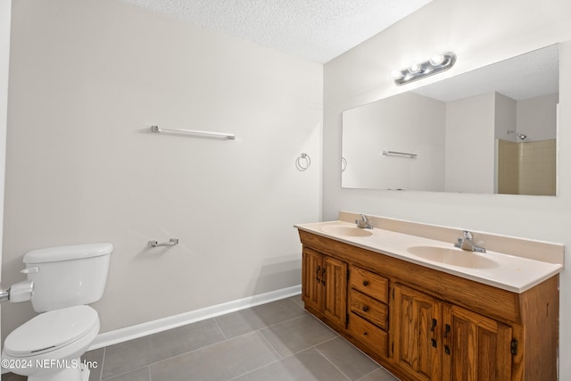 bathroom featuring tile patterned floors, vanity, toilet, and a textured ceiling