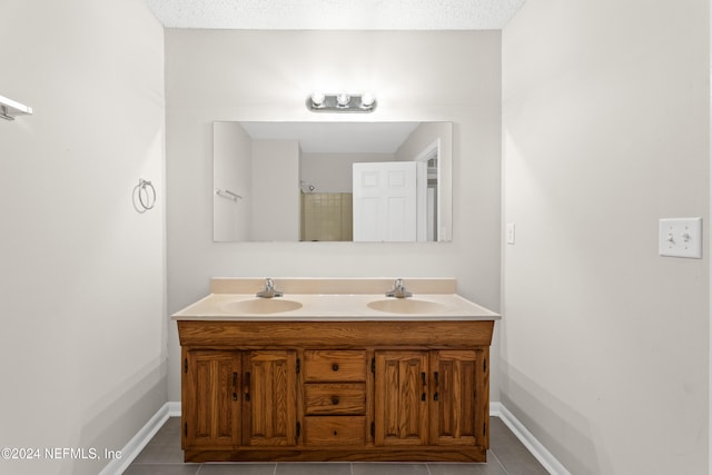 bathroom featuring a textured ceiling, vanity, and tile patterned floors