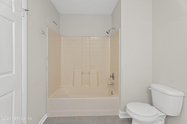 bathroom with shower / washtub combination, tile patterned flooring, a textured ceiling, and toilet