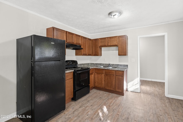 kitchen featuring sink, crown molding, light hardwood / wood-style floors, a textured ceiling, and black appliances