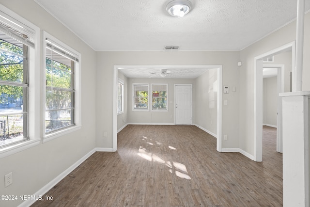 interior space featuring ceiling fan, wood-type flooring, and a textured ceiling