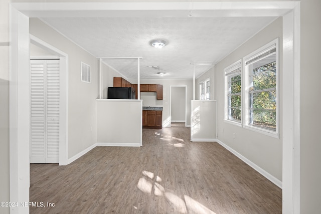 unfurnished living room with wood-type flooring and a textured ceiling