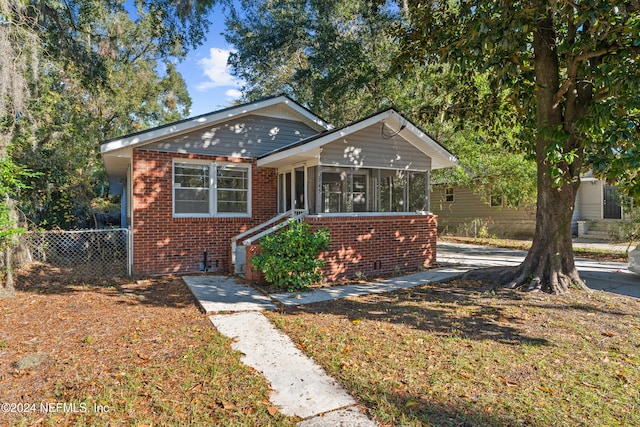 bungalow-style house featuring a front yard and a sunroom