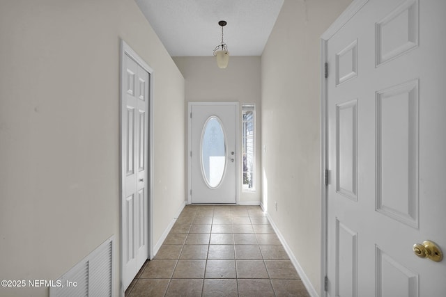 tiled foyer entrance featuring a textured ceiling