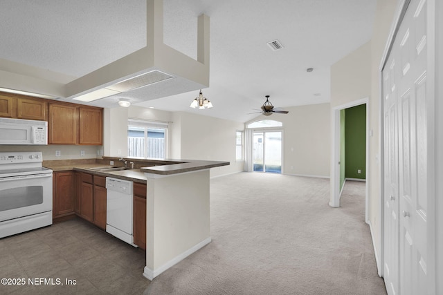 kitchen with sink, white appliances, plenty of natural light, light carpet, and kitchen peninsula