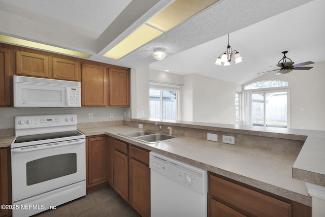 kitchen featuring pendant lighting, sink, dark tile patterned floors, white appliances, and a textured ceiling