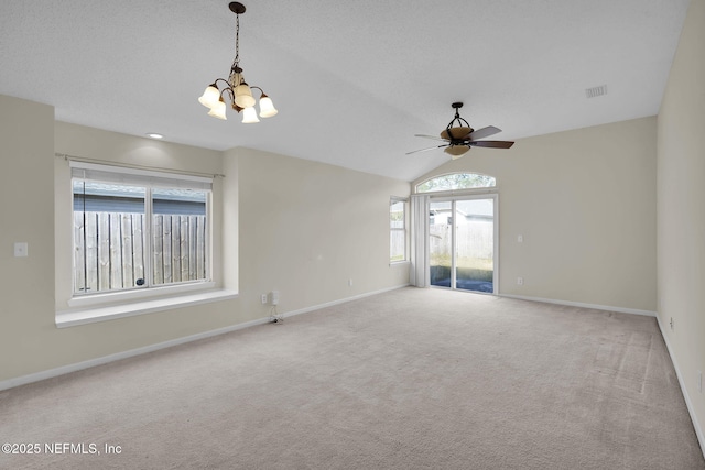 spare room featuring ceiling fan with notable chandelier, light carpet, lofted ceiling, and a textured ceiling