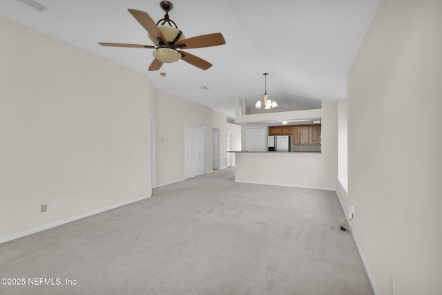 unfurnished living room with light carpet, ceiling fan with notable chandelier, and high vaulted ceiling