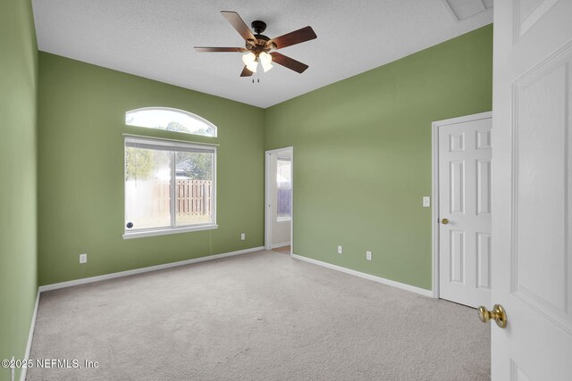 carpeted empty room with ceiling fan and a textured ceiling