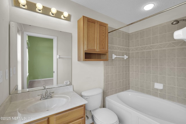 full bathroom featuring vanity, tiled shower / bath combo, a textured ceiling, and toilet