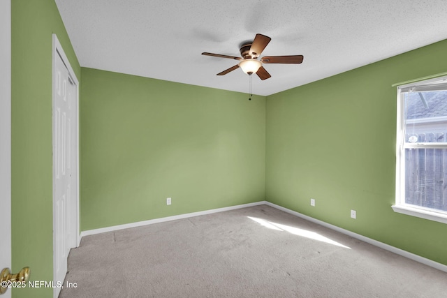 carpeted empty room featuring ceiling fan and a textured ceiling