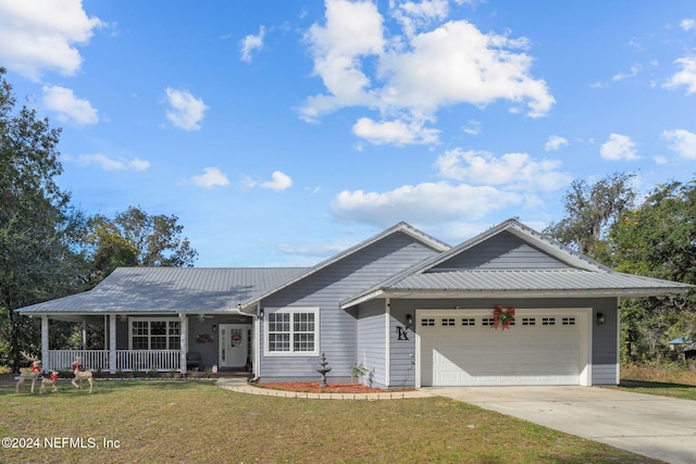 single story home with covered porch, a garage, and a front lawn