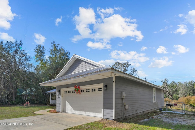 view of side of property featuring a garage and a yard