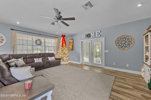 living room with dark wood-type flooring, a healthy amount of sunlight, and a textured ceiling