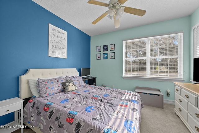 bedroom with ceiling fan, a textured ceiling, and light carpet