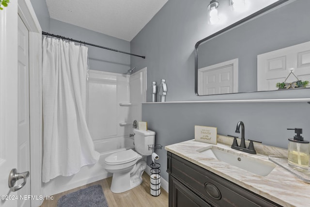 full bathroom featuring shower / bath combo, vanity, toilet, a textured ceiling, and wood-type flooring