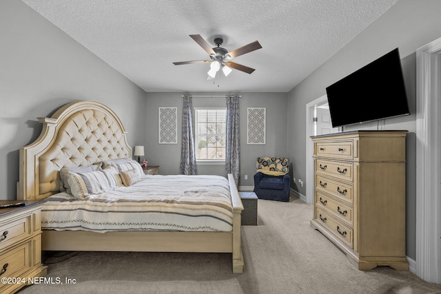 carpeted bedroom featuring a textured ceiling and ceiling fan