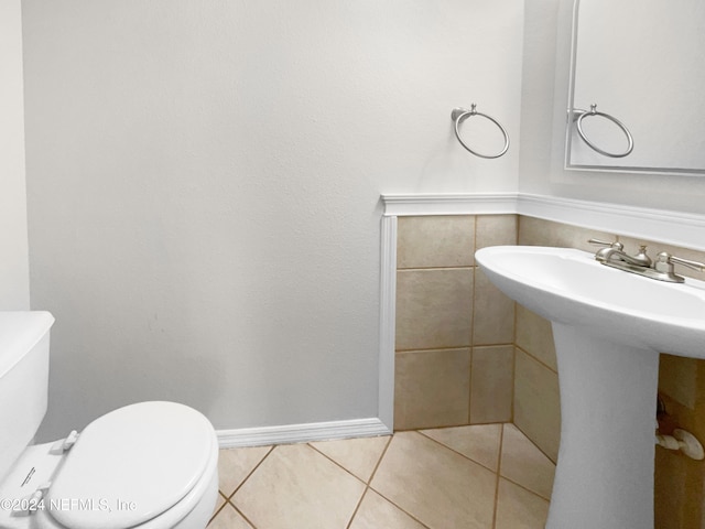 bathroom with toilet, tile patterned floors, and sink