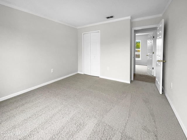 unfurnished bedroom featuring carpet floors, a closet, and crown molding