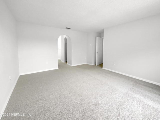 carpeted spare room with a textured ceiling