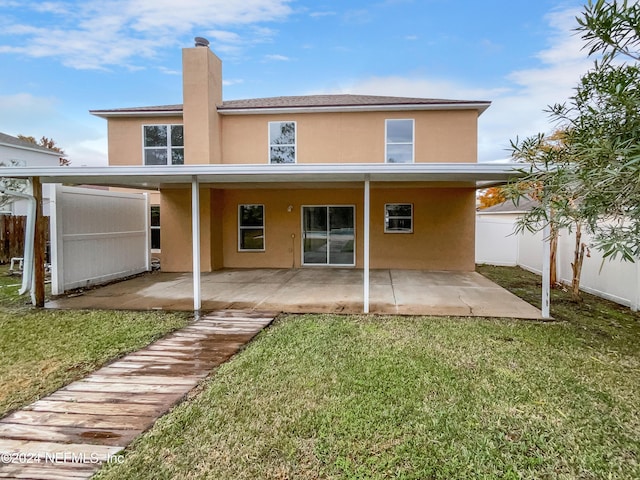 rear view of house with a patio area and a lawn