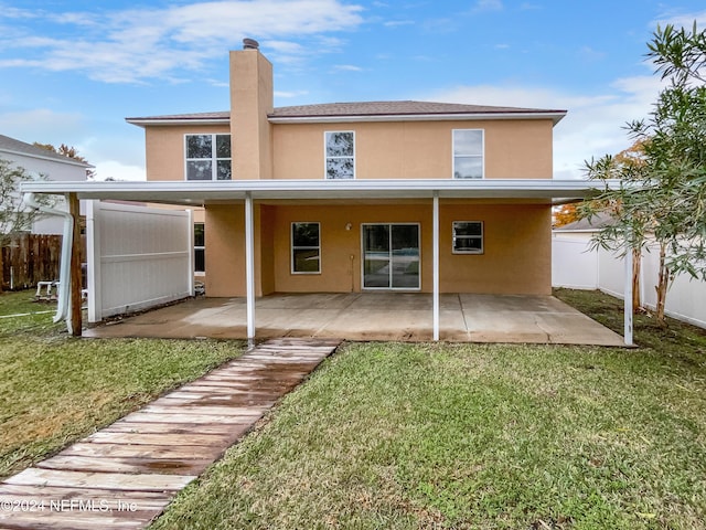 rear view of property featuring a patio and a lawn