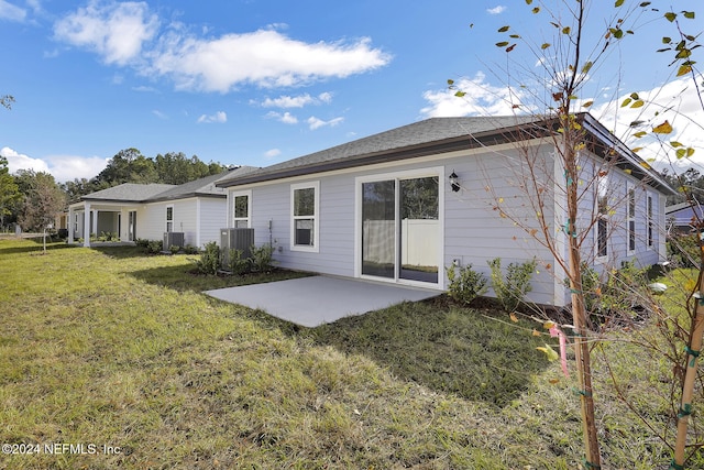 back of house featuring a lawn, cooling unit, and a patio area