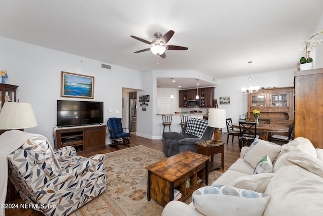 living room with ceiling fan with notable chandelier and wood-type flooring