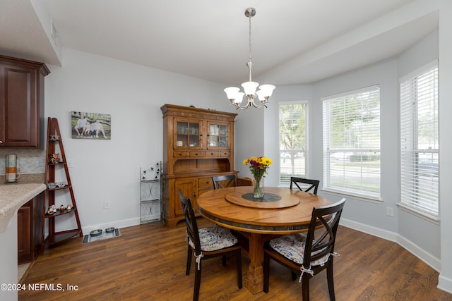 dining room with dark hardwood / wood-style flooring and a chandelier