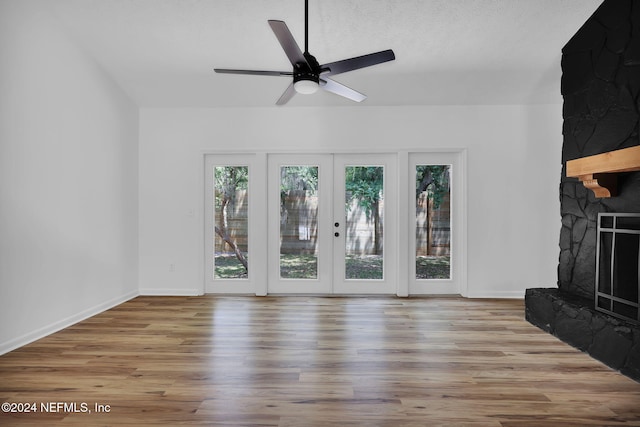 unfurnished living room with ceiling fan, french doors, and light hardwood / wood-style flooring