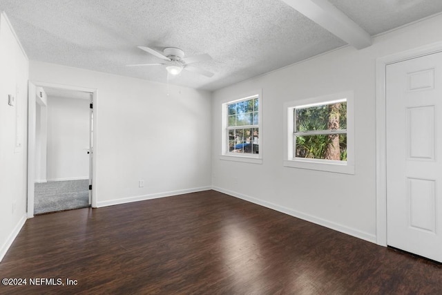 unfurnished room with beam ceiling, ceiling fan, dark hardwood / wood-style flooring, and a textured ceiling