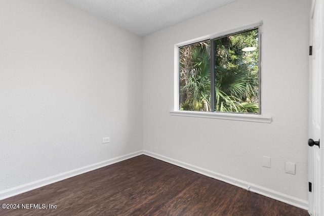 empty room with dark wood-type flooring