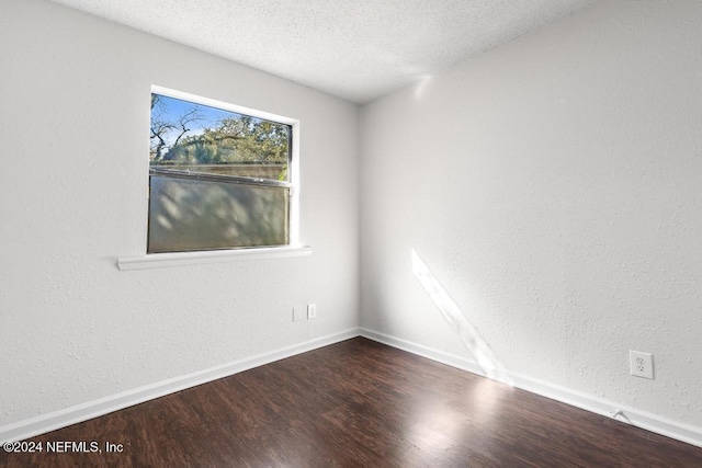 empty room featuring wood-type flooring and a textured ceiling