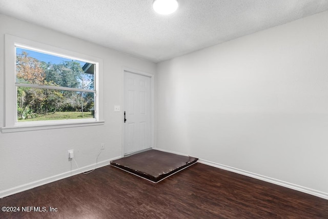 spare room featuring wood-type flooring and a textured ceiling