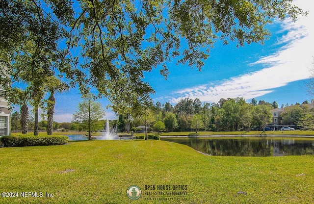 view of property's community with a water view and a yard