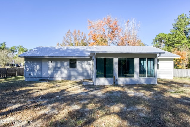 rear view of house featuring a sunroom