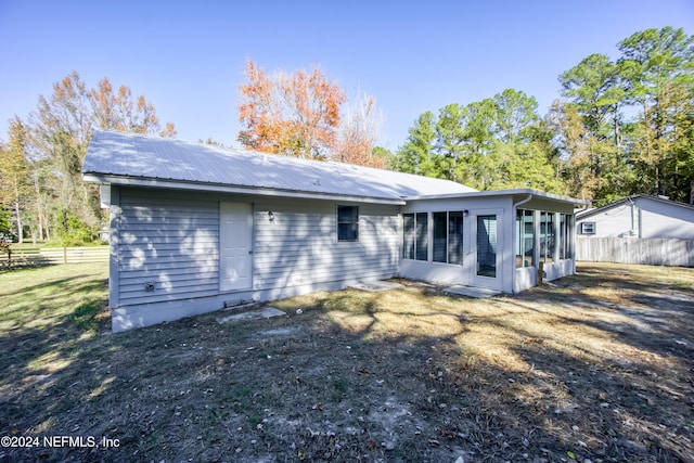 rear view of house featuring a sunroom