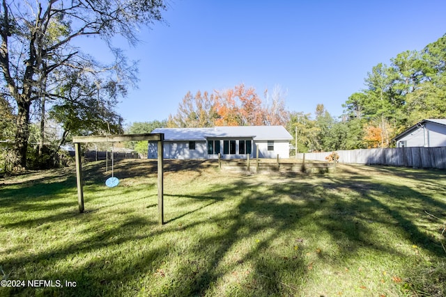 rear view of house featuring a yard