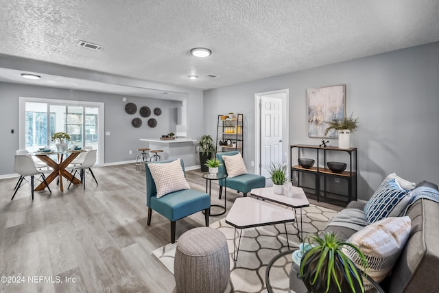 living room featuring a textured ceiling and light hardwood / wood-style floors