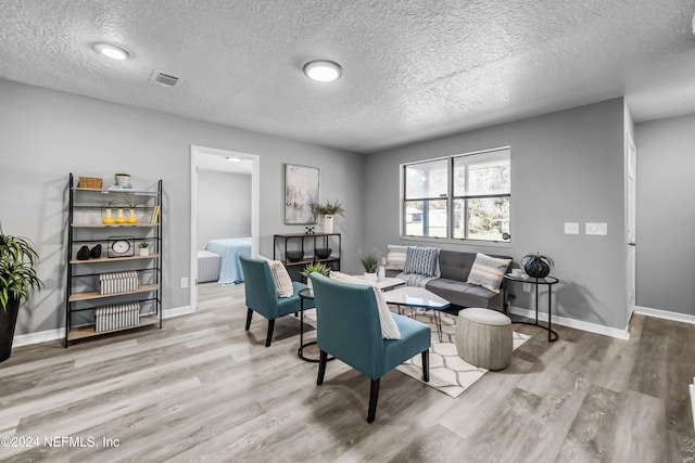 living room with a textured ceiling and hardwood / wood-style flooring