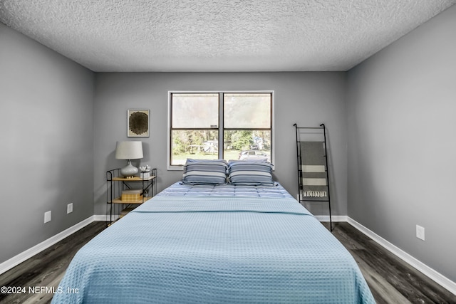 bedroom featuring dark wood-type flooring and a textured ceiling