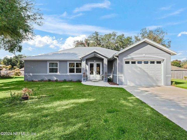 ranch-style home featuring a front lawn, a garage, and french doors