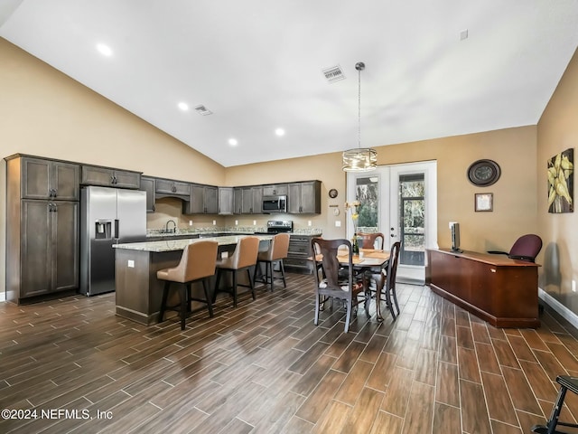 dining room featuring french doors, dark wood-type flooring, vaulted ceiling, and sink