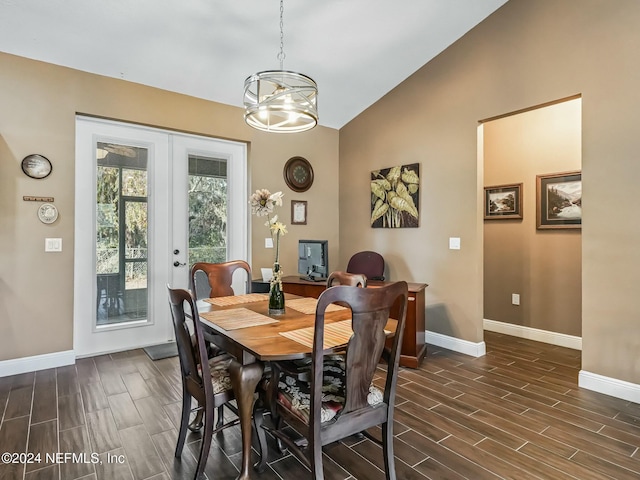 dining area featuring dark hardwood / wood-style floors, an inviting chandelier, french doors, and vaulted ceiling