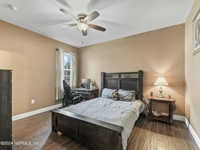 bedroom featuring a textured ceiling, ceiling fan, and dark hardwood / wood-style floors