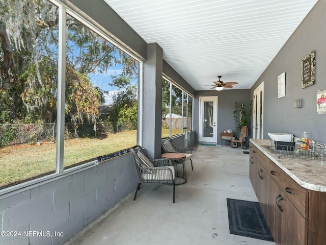 unfurnished sunroom with ceiling fan