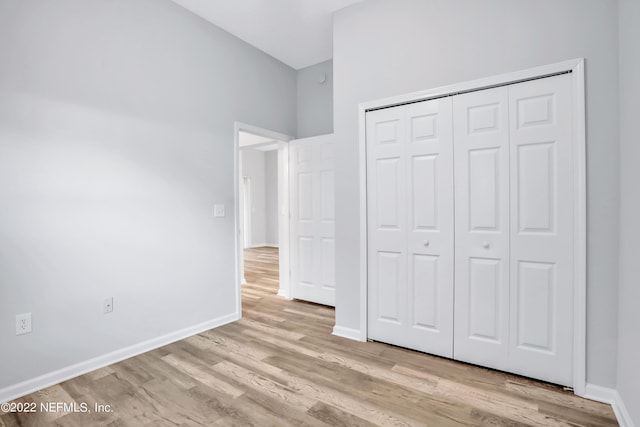 unfurnished bedroom with a closet and light hardwood / wood-style floors