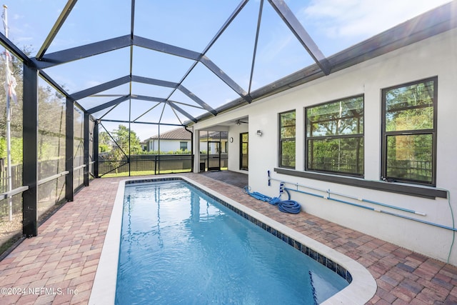 view of swimming pool featuring a lanai, a patio, and ceiling fan